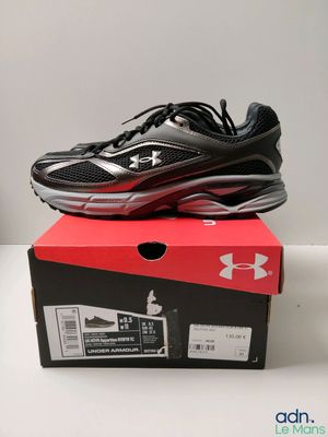 une paire de chaussures de course noires et rouges posée sur une boîte