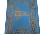 an old blue book with gold trimming and ornate borders