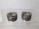 pair of silver plated tea light holders on a clear glass table