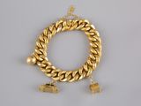 a gold chain bracelet with charms on a white background