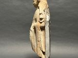 an ancient statue of a woman holding a shield on a wooden base