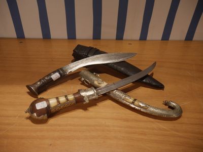 deux couteaux posés sur une table en bois