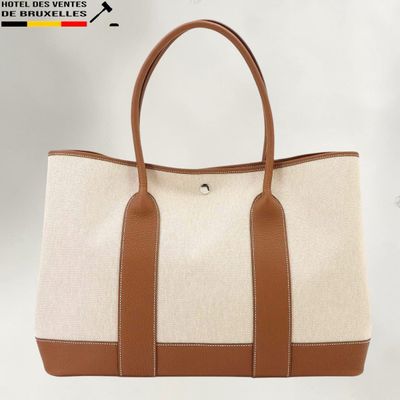 a white and brown tote bag sitting on top of a white table