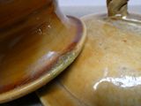 un gros plan d'un vase marron muni d'un couvercle