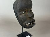 a close up of a mask on a stand on a white surface