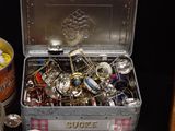 a metal box filled with assorted items on a table