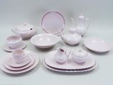a lot of white and pink dishes and cups on the table
