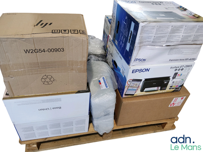 une pile de cartons posée sur une palette sur laquelle se trouve une imprimante