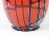 a red vase with a blue and white design on it