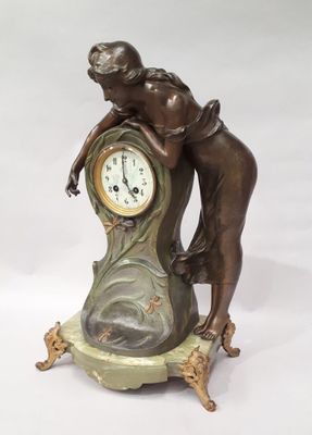 une statue en bronze représentant une femme appuyée contre une horloge