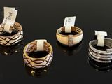three different rings with tags on them sitting on a black surface