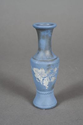 un petit vase bleu orné d'un motif blanc