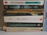 many books stacked on top of each other on a table