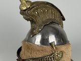 un vieux casque orné d'une plume, posé sur une surface blanche