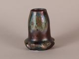 a close up of a vase on a table with a white background