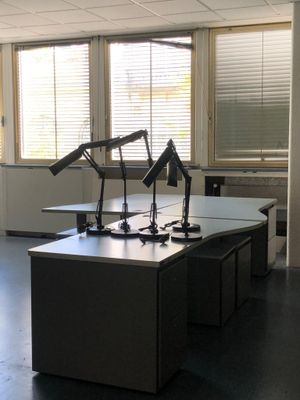 un bureau sur lequel se trouvent deux lampes, dans une pièce vide