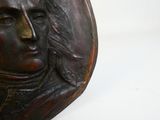 a statue of a man with long hair on a white surface