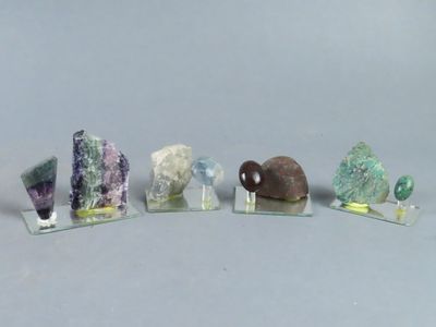 Plusieurs types de roches et de pierres sont présentés sur des socles en acrylique transparent.