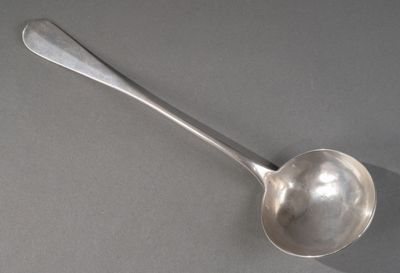 une cuillère en argent avec un manche de cuillère sur une table