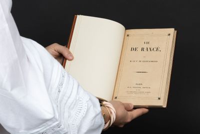 quelqu'un tient un livre à la main et celui-ci est ouvert