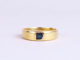 une bague en or sertie d'un saphir bleu au centre