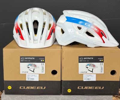 Deux casques sont posés sur des cartons, sur une table.