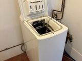 a washing machine that is sitting in the corner of a room