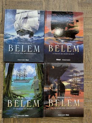 trois livres posés sur un plancher en bois, avec un bateau en arrière-plan