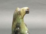 a figurine of a bear sitting on the ground