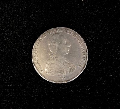 a close up of a silver coin on a black surface