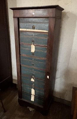 une grande armoire en bois comportant plusieurs tiroirs et des étiquettes