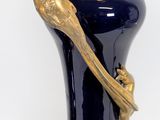 a blue vase with a gold handle on a white background