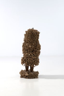 une petite sculpture représentant un arbre, réalisée à partir de petits cailloux