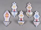 six ceramic wall hangings with crosses, crosses, and flowers