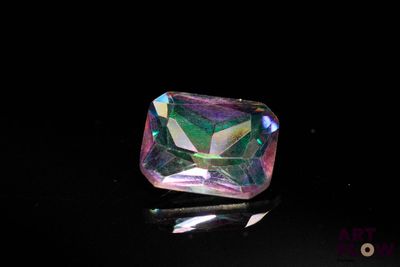 une image représentant un diamant rose et vert sur un fond noir