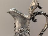 a silver pitcher that is sitting on a table