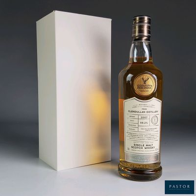 a bottle of whisky sitting next to a box on a table