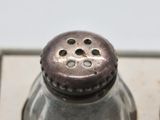a silver salt and pepper shaker sitting on top of a counter