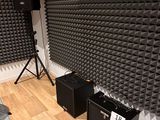 two speakers and a speaker stand in the corner of a room