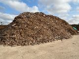 a large pile of wood chips on the side of the road