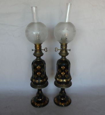 pair of antique oil lamps with glass globes on each of them