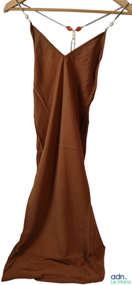 une robe marron suspendue à un cintre en bois