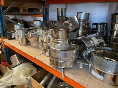 de nombreuses casseroles et poêles sur une étagère dans un magasin