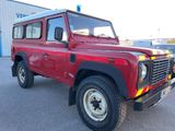 une photo d'un Land Rover rouge garé devant un immeuble