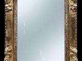 un miroir à cadre doré sur fond noir