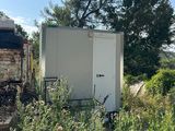 une petite boîte blanche posée au milieu d'un champ