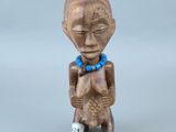 figurine représentant un homme portant une perle bleue autour du cou