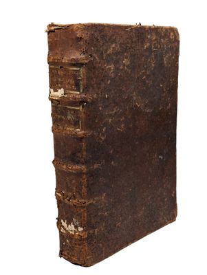 un vieux livre est posé sur une surface blanche