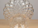 a glass vase with a flower on it on a table