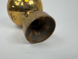 a gold vase that is sitting on a white surface
